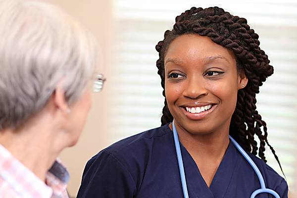 Health professional smiling at elderly woman
