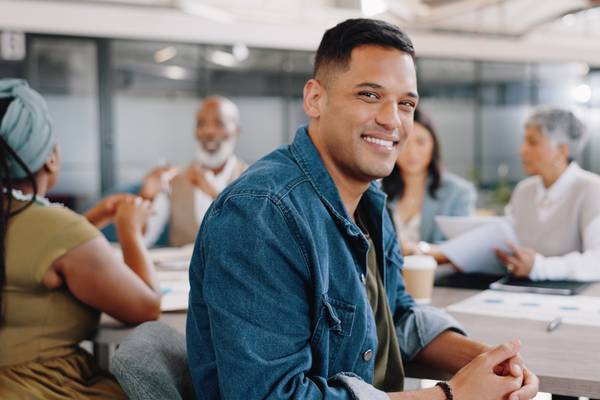 Smile, portrait of male worker in a meeting planning goals for training in an office building